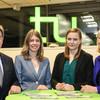 Four women and one man are standing at a bar table, the TU logo shines in the background. 
