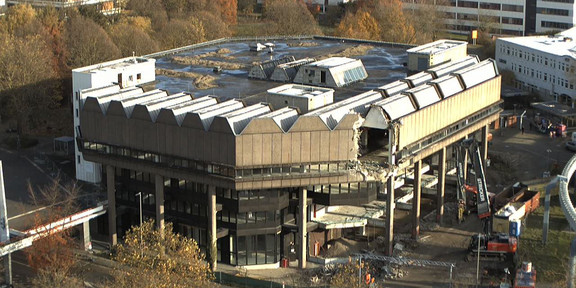 Ein Abrissbagger entfernt die Fassade an der S-Bahn-Seite