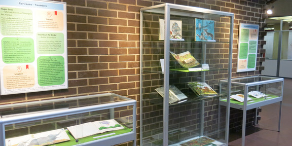 Vitrinen mit Büchern und Plakate zur Ausstellung im Foyer der UB
