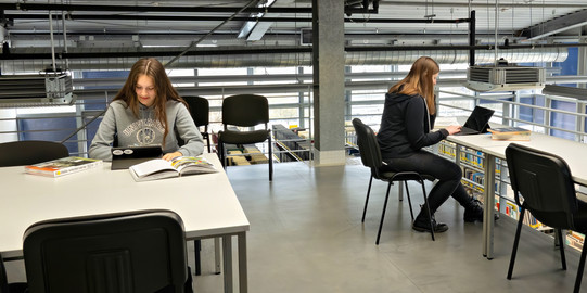 2 junge Frauen lernen mit Büchern und Tablet in der Bereichsbibliothek Raumplanung