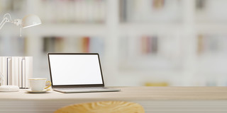 Laptop und Bücher auf einem Tisch Ein Laptop, Bücher, eine Leselampe und eine Kaffeetasse auf einem Tisch