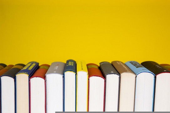 A row of books from below A row with colorful books and white cut from below