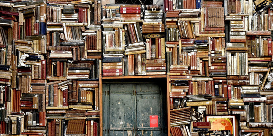 Alte Bücher in Regalen Alte, zum Teil stockfleckige Bücher in Regalen rund um eine Holztür