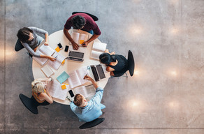Five students learn at a round table, photographed from above