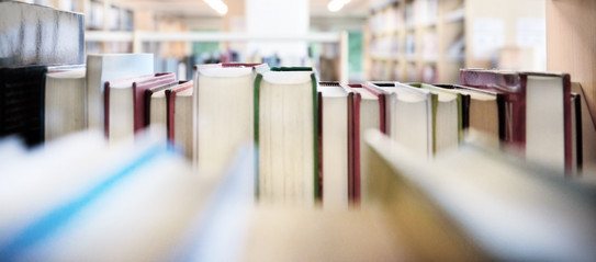 Public library bookshelf with books from behind