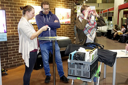 Drei Personen interessieren sich für das Angebot der Veranstaltung