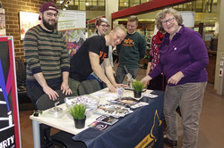 Fünf Personen stehen um einen Stand, an dem eine Verlosung stattfindet