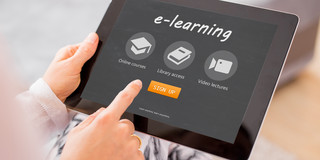 A woman's hands hold a tablet that says "e-learning" on it