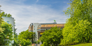 Gebäude Universitätsbibliothek Dortmund Gebäude der Universitätsbibliothek im Sommer, im Vordergrund grüne Bäume