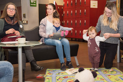 Zwei Kinder mit ihren Müttern spielen gemeinsam