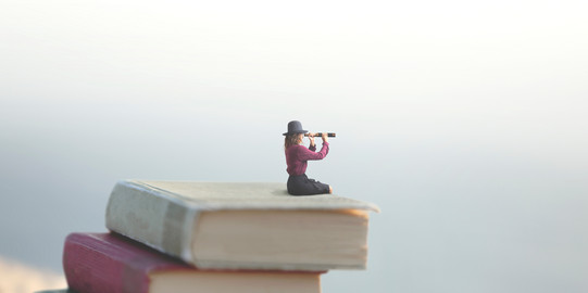 Miniaturfrau auf Bücherstapel