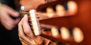 Two hands playing the guitar.