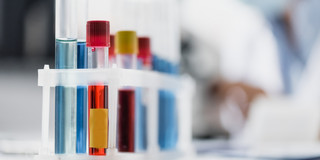 A set of test tubes filled with various red and blue liquids.